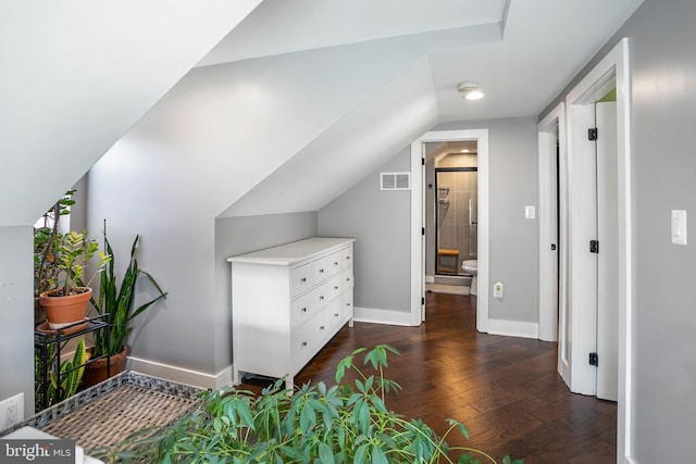 bonus room with dark wood finished floors, lofted ceiling, baseboards, and visible vents