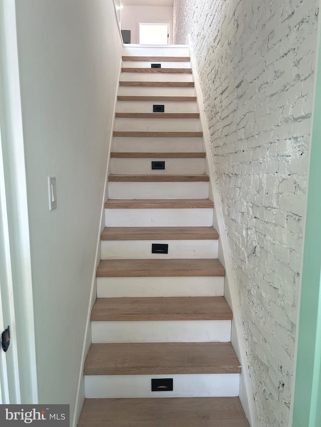 stairs featuring brick wall