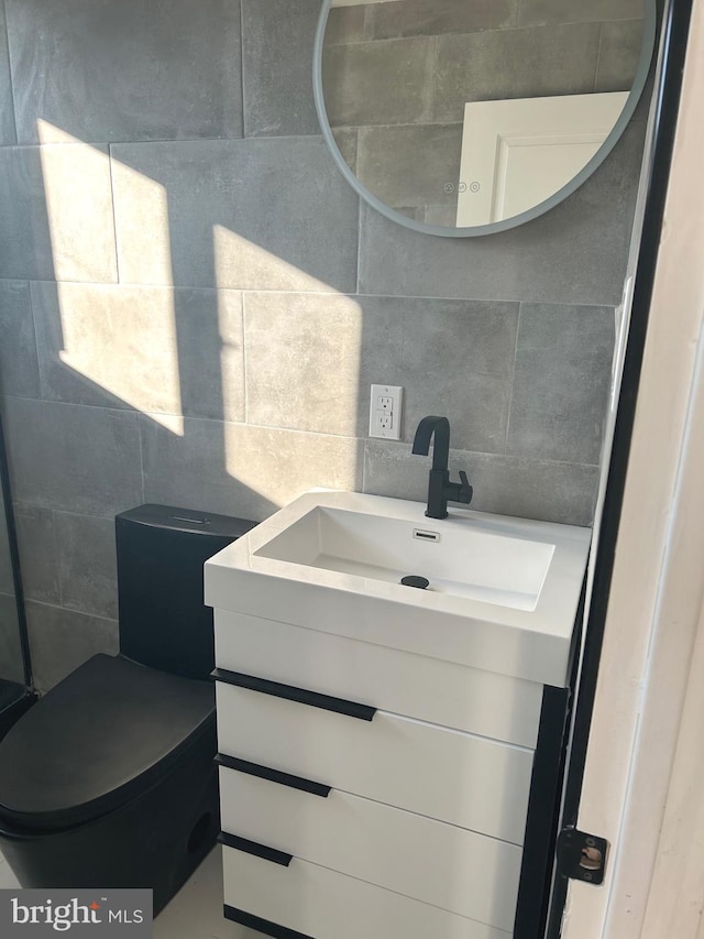 bathroom with tasteful backsplash, tile walls, and vanity