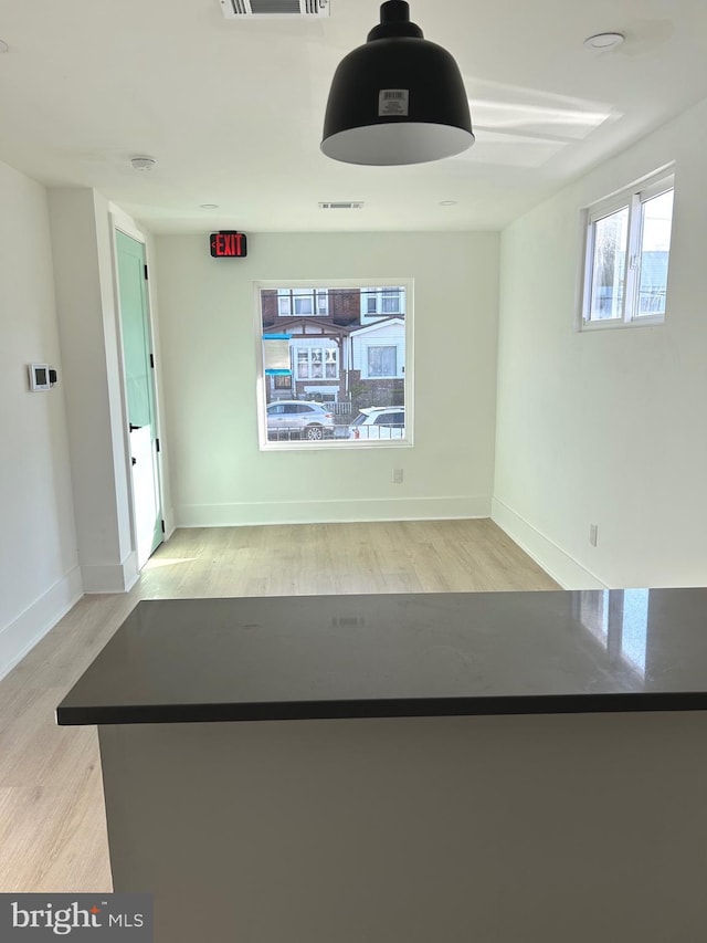 interior space with visible vents, baseboards, and wood finished floors