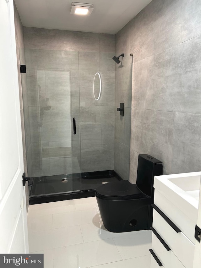 bathroom featuring toilet, tile walls, a shower stall, and tile patterned flooring