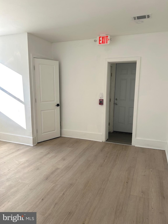 unfurnished room featuring visible vents, baseboards, and light wood-style floors