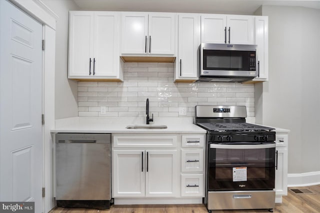 kitchen featuring a sink, white cabinetry, appliances with stainless steel finishes, and light countertops