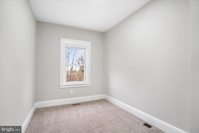 empty room with visible vents, baseboards, and carpet