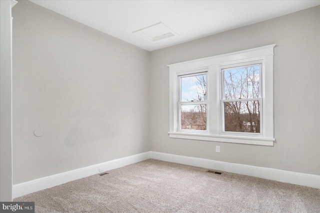 carpeted spare room featuring visible vents and baseboards