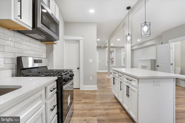 kitchen featuring light wood-type flooring, recessed lighting, stainless steel appliances, white cabinets, and baseboards