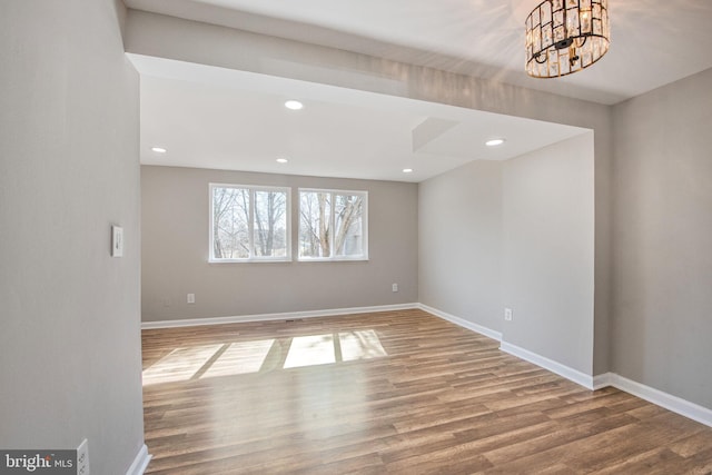 empty room featuring recessed lighting, baseboards, and wood finished floors