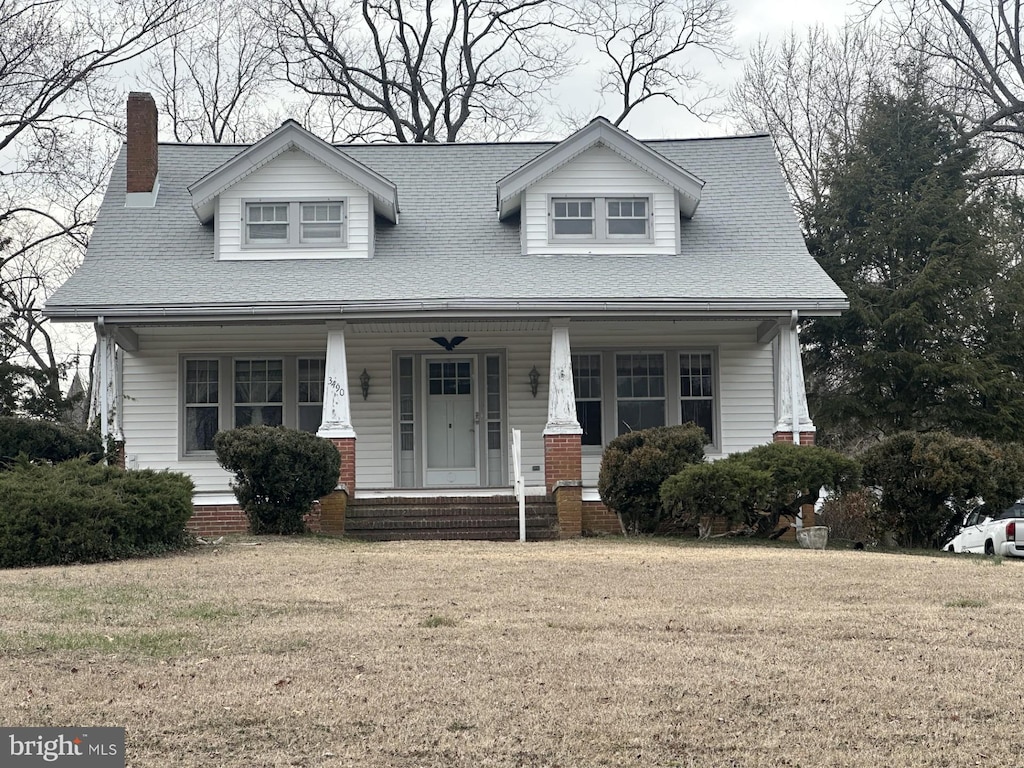 view of front of property featuring covered porch and a front lawn