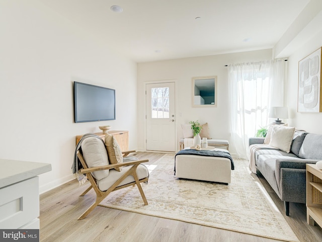 living area featuring light wood-style flooring and baseboards