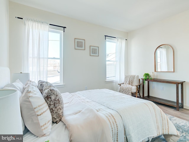 bedroom with multiple windows and wood finished floors