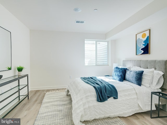 bedroom featuring visible vents, baseboards, and light wood-style floors