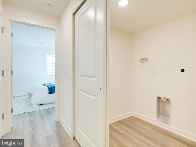 washroom with laundry area, electric dryer hookup, light wood-type flooring, and baseboards