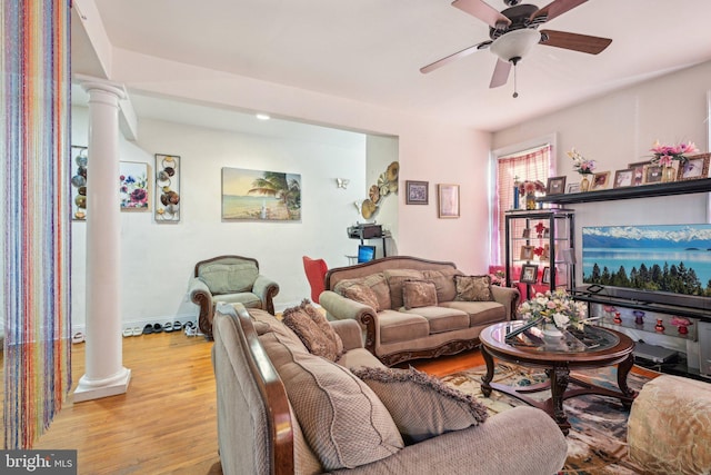 living room featuring wood finished floors, ornate columns, and ceiling fan