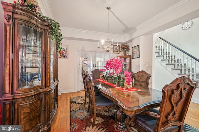 dining room with stairway, crown molding, and light wood-type flooring