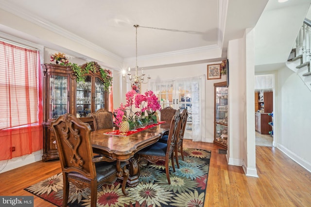 dining space with a wealth of natural light, light wood-type flooring, and crown molding