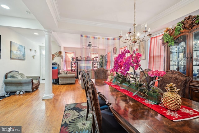 dining space with a ceiling fan, wood-type flooring, ornate columns, and ornamental molding