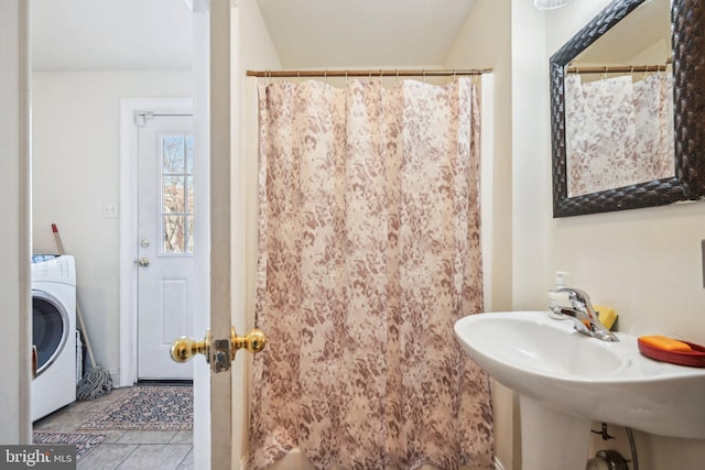 bathroom featuring curtained shower, tile patterned floors, washer / clothes dryer, and a sink