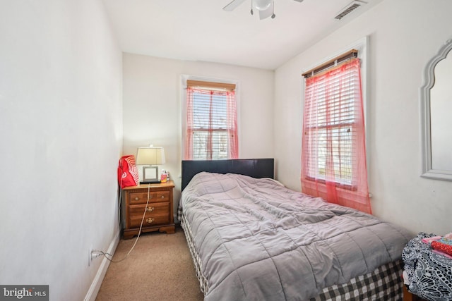 bedroom with visible vents, multiple windows, carpet flooring, and baseboards