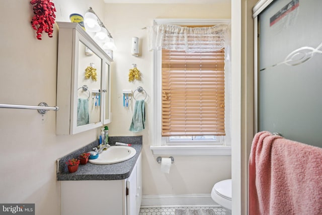 bathroom featuring toilet, vanity, and baseboards