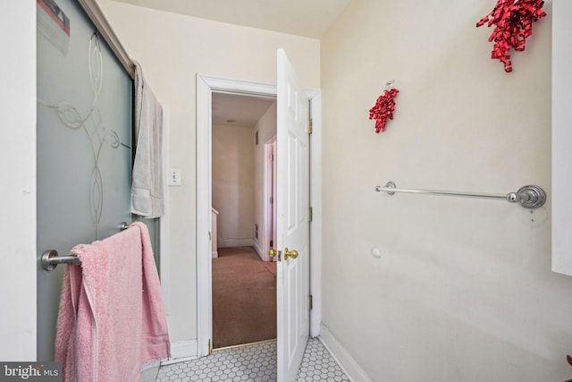 bathroom with a shower and baseboards