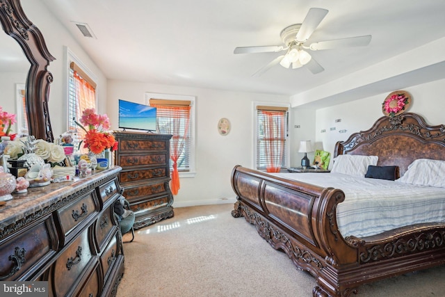 bedroom with visible vents, light carpet, baseboards, and ceiling fan