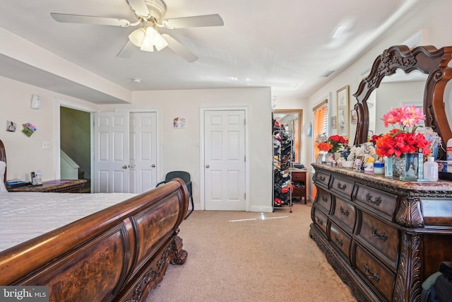 bedroom featuring visible vents, light colored carpet, and a ceiling fan