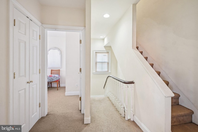 interior space featuring light carpet, recessed lighting, stairs, and baseboards