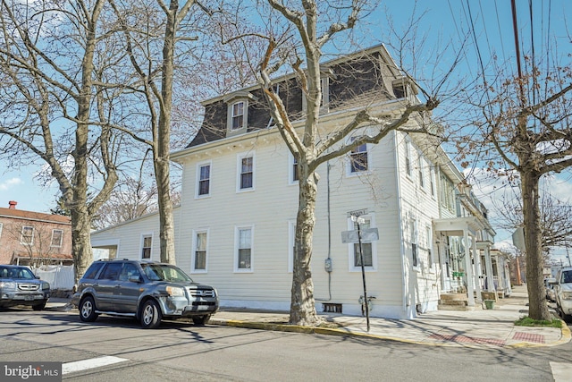 view of side of property with mansard roof