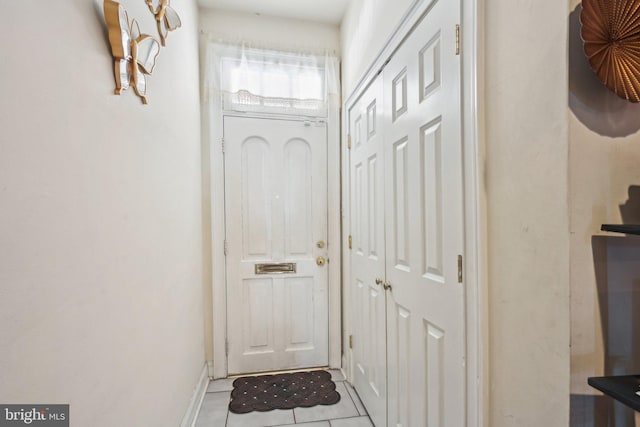 doorway to outside with light tile patterned floors