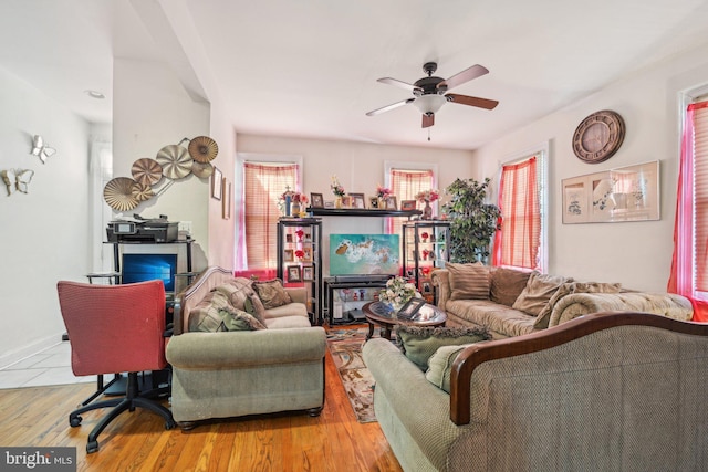 living area featuring a ceiling fan and wood finished floors