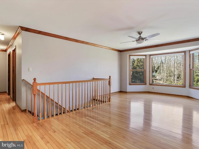 unfurnished room featuring ornamental molding, baseboards, and hardwood / wood-style flooring