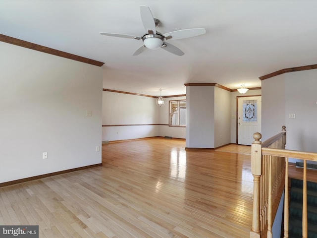 unfurnished living room with light wood-style flooring, baseboards, and ornamental molding