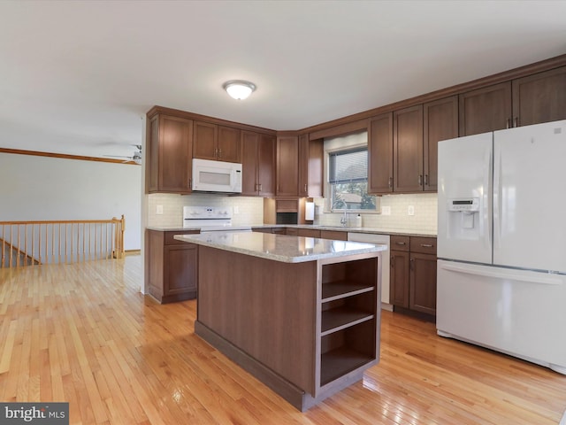 kitchen with decorative backsplash, light wood-style flooring, white appliances, and open shelves