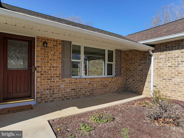 doorway to property with brick siding