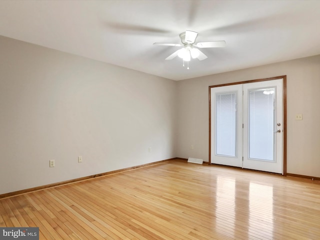 unfurnished room with light wood finished floors, a ceiling fan, and baseboards