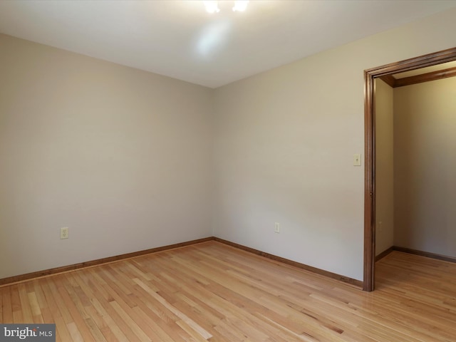 spare room with light wood finished floors and baseboards