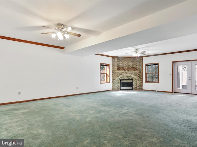 unfurnished living room with a brick fireplace, crown molding, baseboards, and carpet floors