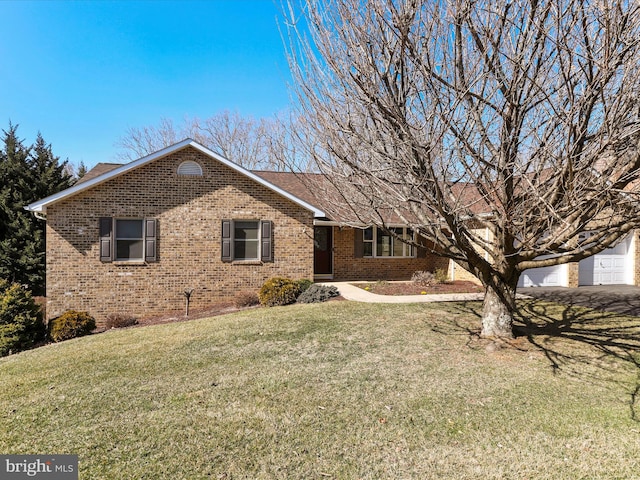 single story home with a front lawn, an attached garage, and brick siding