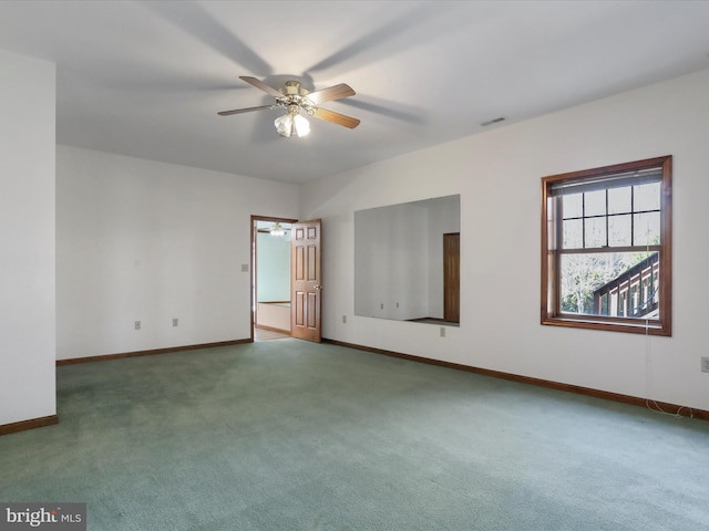 carpeted empty room with visible vents, baseboards, and a ceiling fan