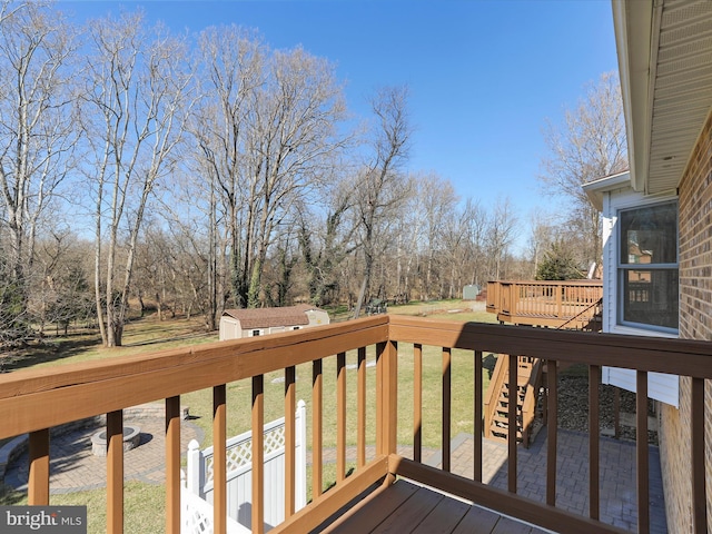 wooden deck featuring an outbuilding and a lawn