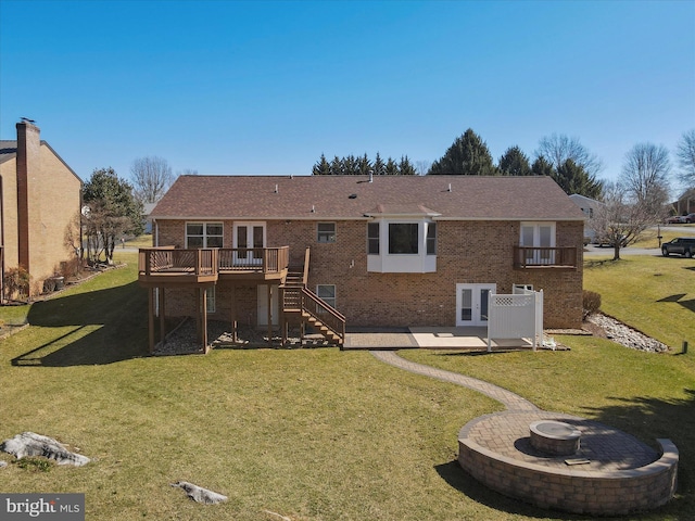 rear view of property with stairway, a wooden deck, a fire pit, a patio area, and brick siding