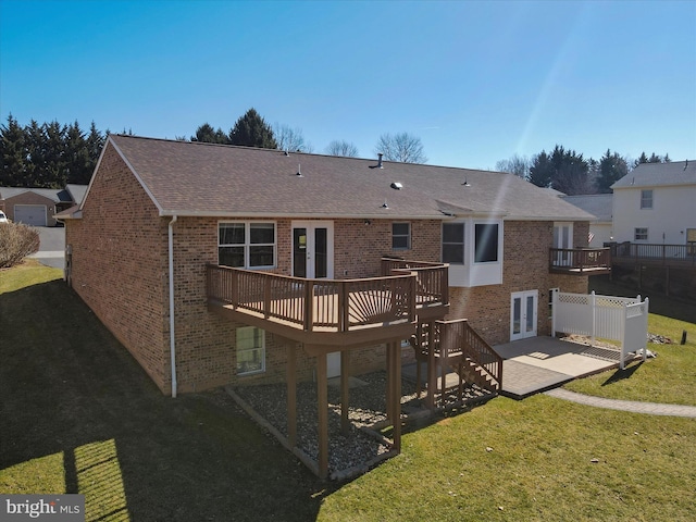 back of house with brick siding, a patio area, a lawn, and french doors