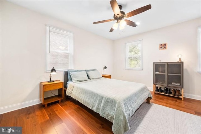 bedroom featuring a ceiling fan, wood finished floors, and baseboards