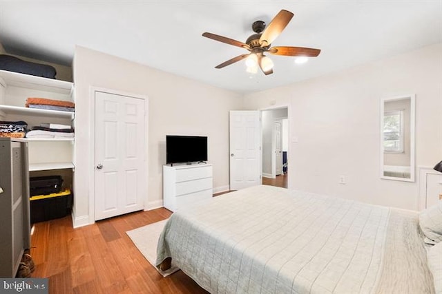 bedroom with a ceiling fan, baseboards, and wood finished floors