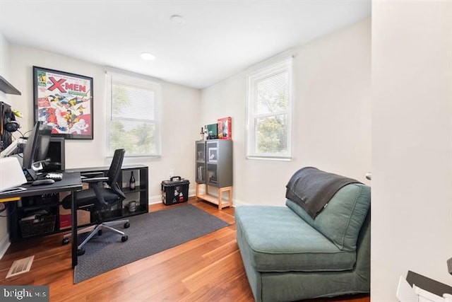 office featuring visible vents, baseboards, and wood finished floors