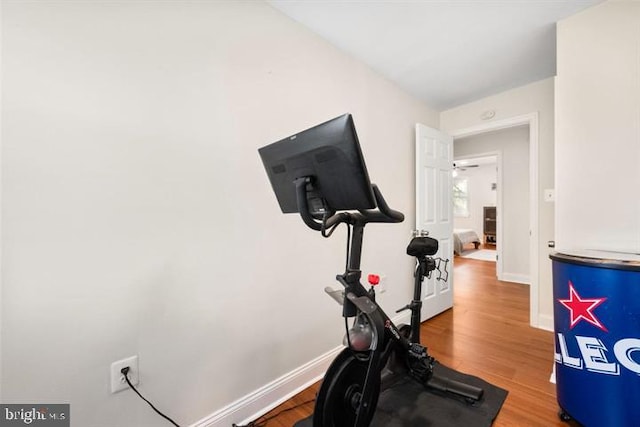 workout area with baseboards and wood finished floors