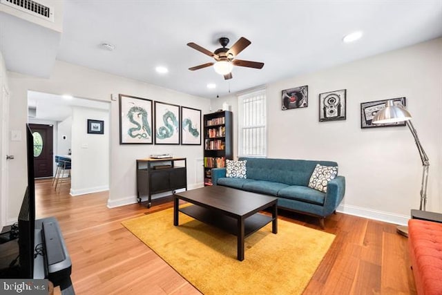 living room featuring a healthy amount of sunlight, visible vents, light wood finished floors, and baseboards