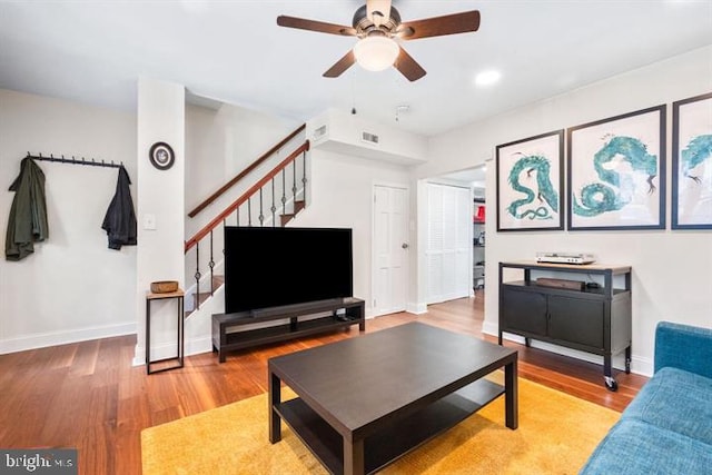 living room with stairway, baseboards, and wood finished floors