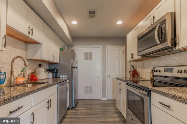 kitchen featuring a sink, stainless steel appliances, visible vents, and white cabinetry