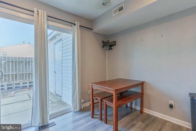 dining room featuring visible vents, baseboards, and wood finished floors